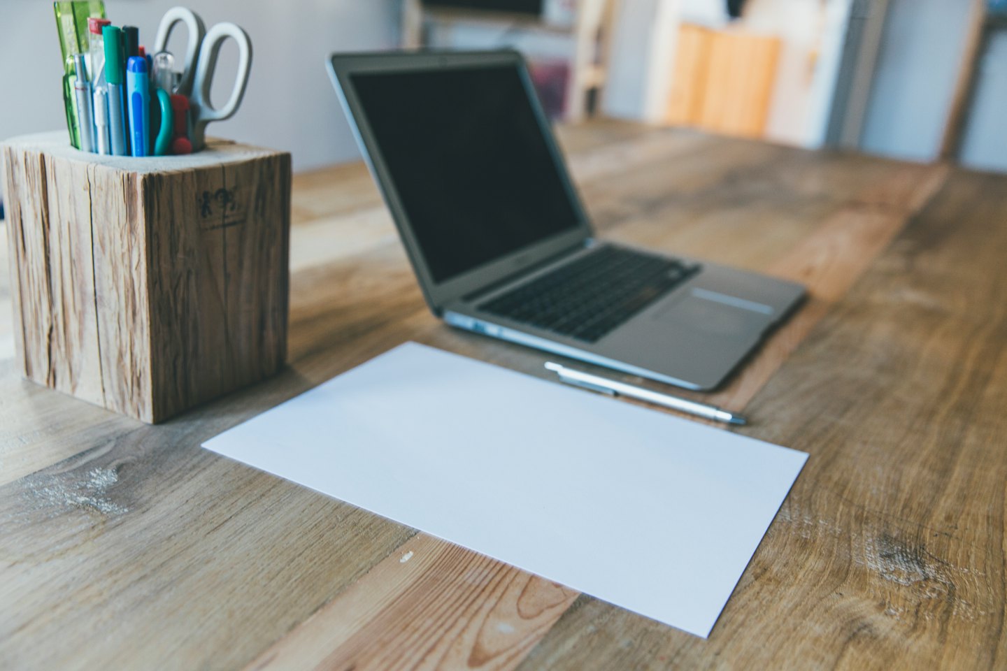 Computer portatile e forniture su una scrivania di legno naturale.