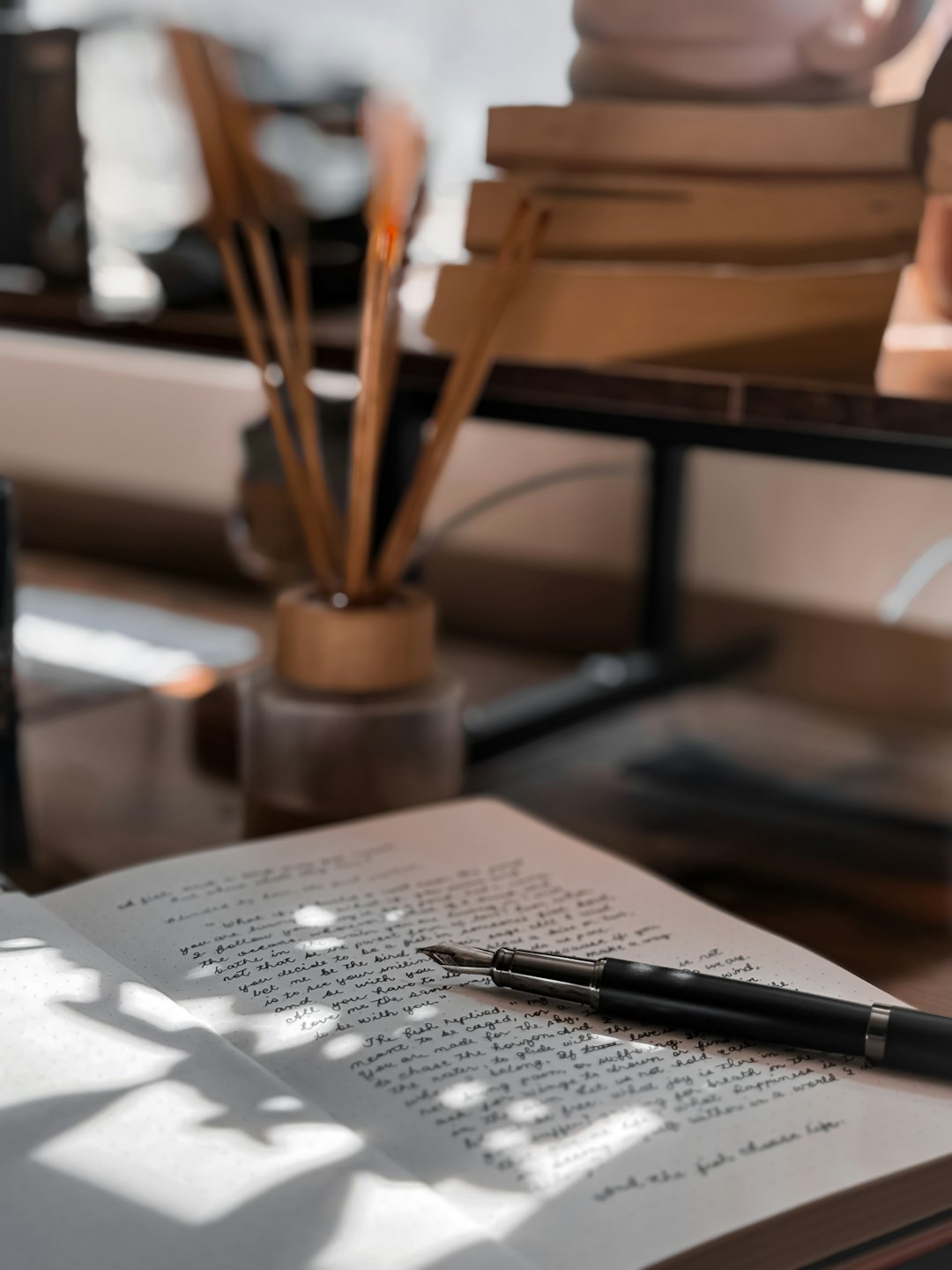 Diario scritto a mano e penna stilografica su una scrivania di legno.