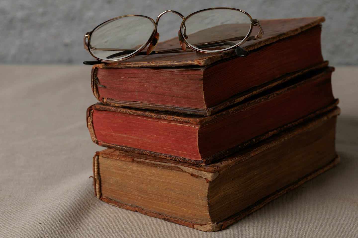 Occhiali da lettura antichi appoggiati su vecchi libri.